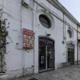 Alla sua base, tra strada San Benedetto e piazza del Ferrarese, sorgono una serie di fabbricati contraddistinti da finestroni ovali. Ospitano esercizi commerciali...